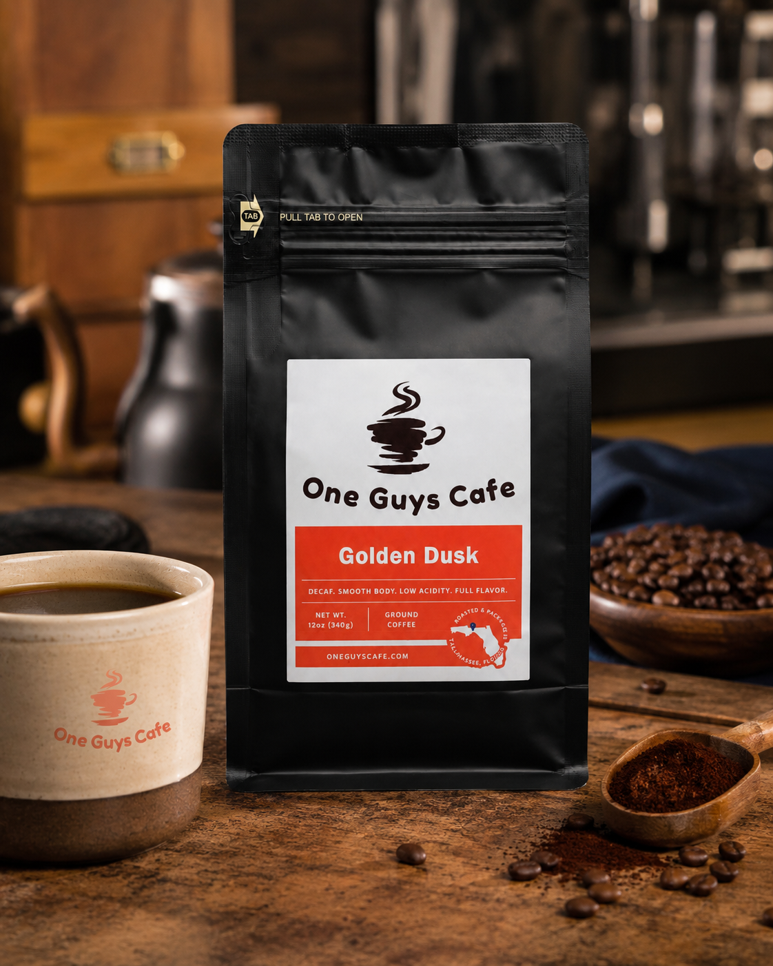 One Guys Cafe Golden Dusk decaf coffee bag in a rustic coffee scene with coffee grounds, beans, and branded mug.